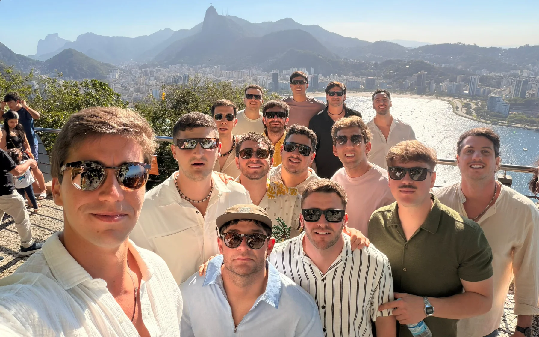 Amigos en un mirador con la costa y las montañas de Río de Janeiro al fondo.